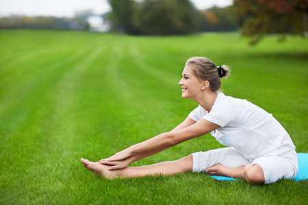 Young girl doing gymnastics in the parkの写真素材
