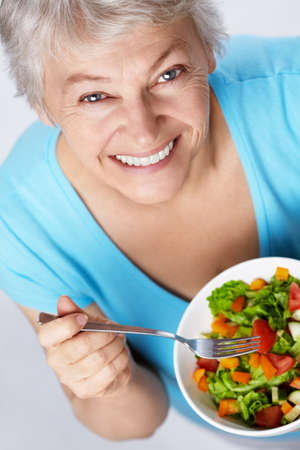 Elderly woman eating saladの写真素材