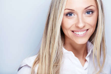 Smiling young woman in white shirtの写真素材