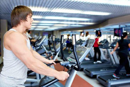 Athletic man on the treadmill in fitness club