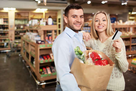 Young couple with a credit card in a storeの写真素材