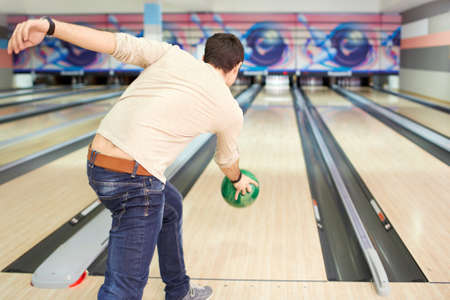 Young man throws a ball in bowlingの写真素材