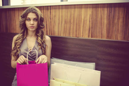 Young girl with shopping bags on a benchの写真素材