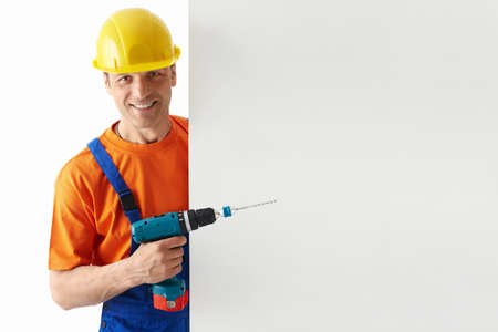 Builder in helmets with a drillの写真素材