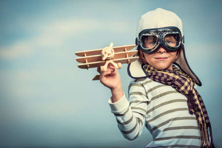 Boy in helmet and glasses with planeの写真素材