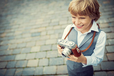 Little boy with a camera on the streetの写真素材