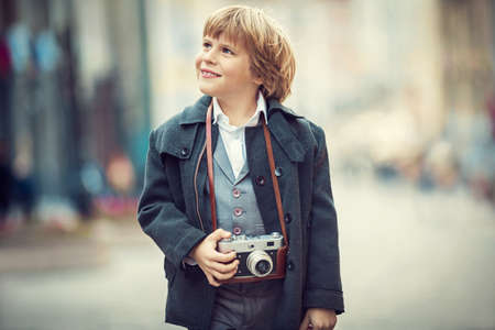 Little boy with a camera on the streetの写真素材