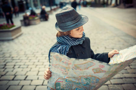 Little boy with map on the streetの写真素材