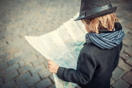 Little boy with a map on the street