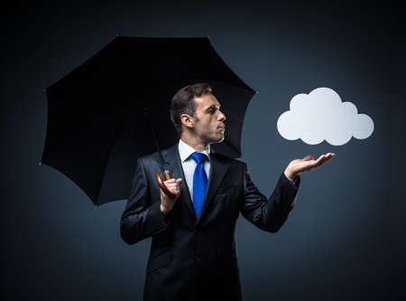 Mature man in suit with umbrellaの写真素材