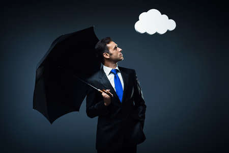 Mature man in suit with umbrellaの写真素材