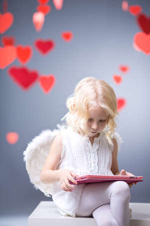 Little angel with the tablet in studio