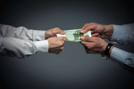 Businessman and businesswoman divide moneyの写真素材