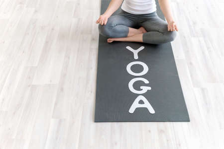 Woman in lotus position with the word "yoga"の写真素材