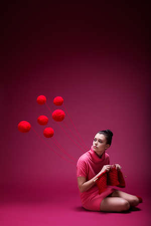 Young girl knits a scarf in studioの写真素材