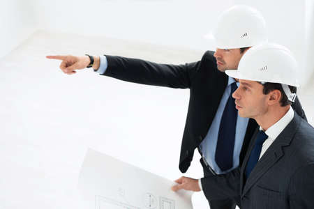 Mature architects in helmets indoor