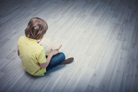Little boy reading a bookの写真素材