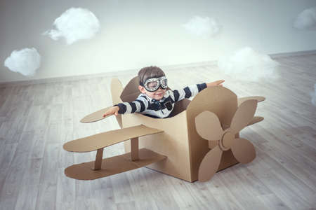 Little boy in a cardboard airplaneの写真素材