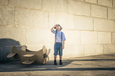 Little boy with a cardboard airplaneの写真素材