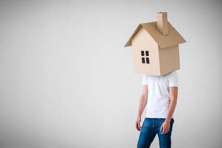 Man with a cardboard house on headの写真素材