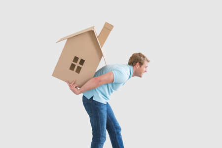 Young man with cardboard houseの写真素材