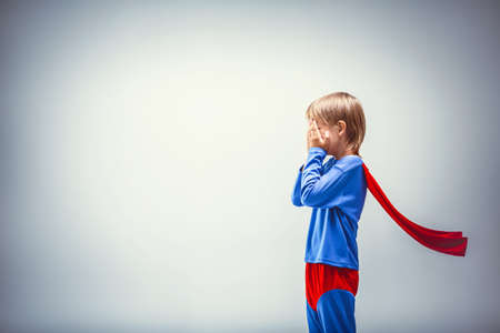 Little superman in a raincoat in studioの写真素材