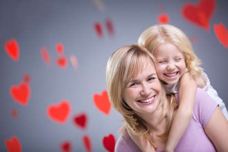 Smiling mother and daughter with heartsの写真素材