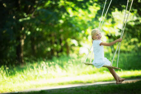 Little girl on a swing in the parkの写真素材