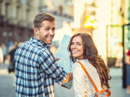 Young couple with a map outdoorsの写真素材