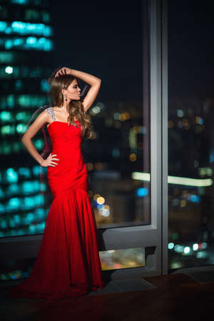 Beautiful young girl in a red dressの写真素材