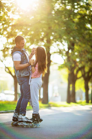 Smiling couple on rollers outdoorsの写真素材