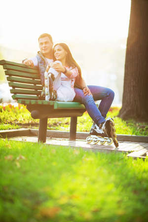 Young couple with rollers on the benchの写真素材