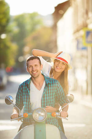 Smiling couple on a scooter outdoorsの写真素材