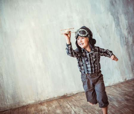 Happy boy running with planeの写真素材