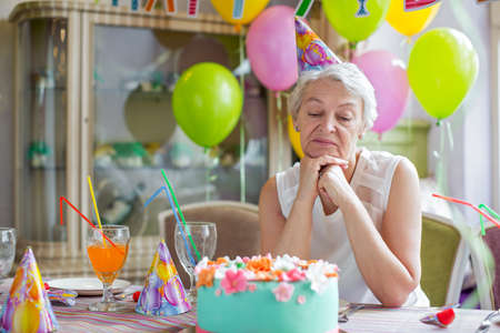 Sad elderly woman at a birthday partyの写真素材