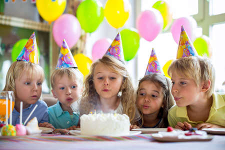 Children blow out the candles on the cakeの写真素材