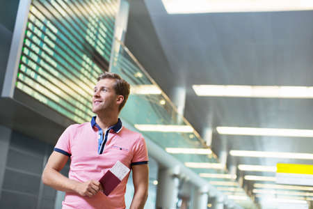 Smiling man with a passport at the airport