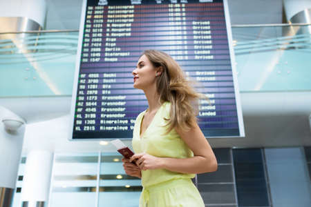 Attractive woman with a passport at the board