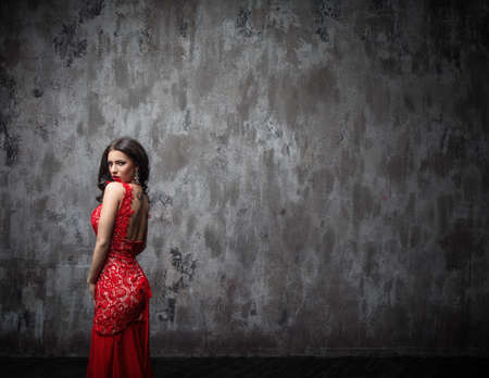 Beautiful young girl in a red dressの写真素材