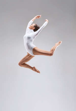 Young slim gymnast in studioの写真素材