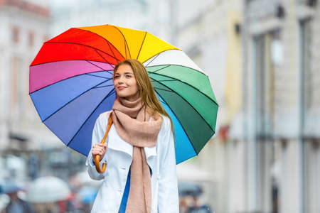 Young girl with an umbrella on the streetの写真素材