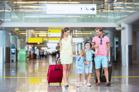 Family with children with a suitcase at the airportの写真素材