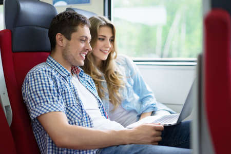 Young couple with a laptop on the trainの写真素材