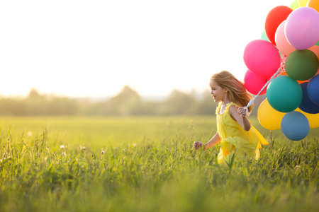 Little girl with balloons outdoorsの写真素材