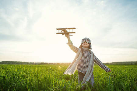 Little boy with wooden airplane in the fieldの写真素材