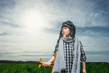 Little boy with wooden airplane outdoorsの写真素材