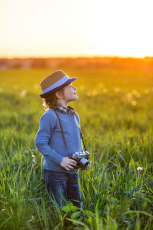 Little boy with a camera in the fieldの写真素材