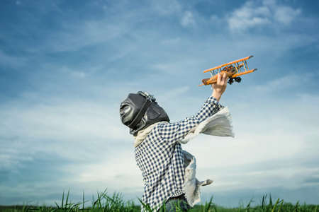 Boy with wooden airplane outdoorsの写真素材