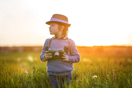 Boy with a camera in the fieldの写真素材