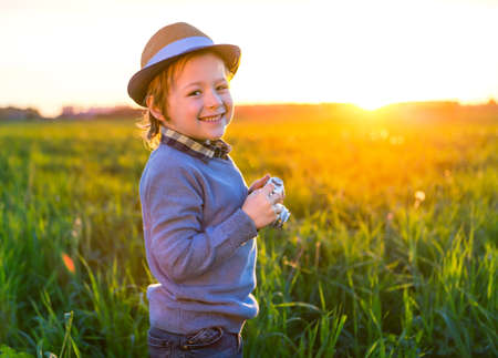 Happy boy with a camera outdoors